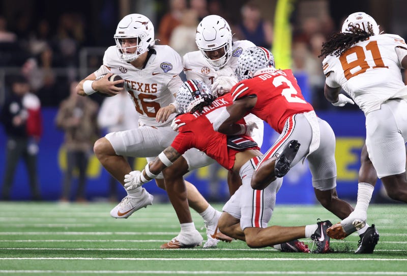 Jan 10, 2025; Arlington, Texas, USA; Texas Longhorns quarterback Arch Manning (16) runs against Ohio State Buckeyes cornerback Jordan Hancock (7) and safety Caleb Downs (2) during the second quarter of the College Football Playoff semifinal in the Cotton Bowl at AT&T Stadium.