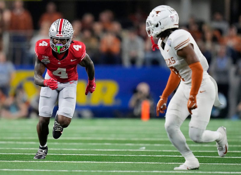 Ohio State Buckeyes wide receiver Jeremiah Smith (4) tries to get open against Texas Longhorns defensive back Jahdae Barron (7) in the fourth quarter of the Cotton Bowl Classic during the College Football Playoff semifinal game at AT&T Stadium in Arlington, Texas on January, 10, 2025.