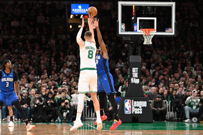 Boston, Massachusetts, USA; Boston Celtics center Kristaps Porzingis (8) shoots over Orlando Magic center Wendell Carter Jr. (34) during the first half at TD Garden.