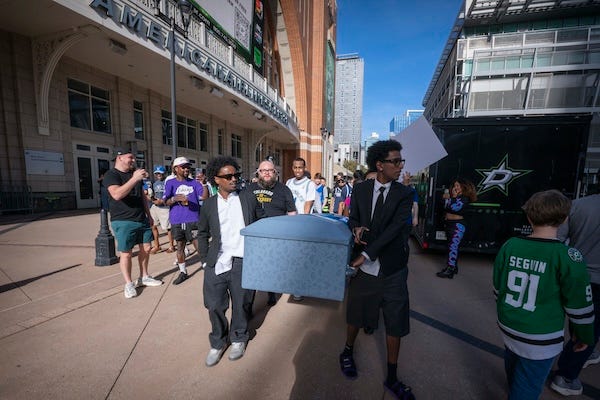 Mavs fans walking around the American Airlines Center carrying a coffin