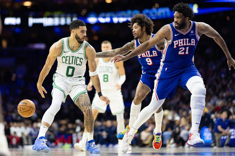 Boston Celtics forward Jayson Tatum (0) passes the ball back to center Kristaps Porzingis (8) in front of Philadelphia 76ers center Joel Embiid (21) and guard Kelly Oubre Jr. (9) during the second quarter at Wells Fargo Center.