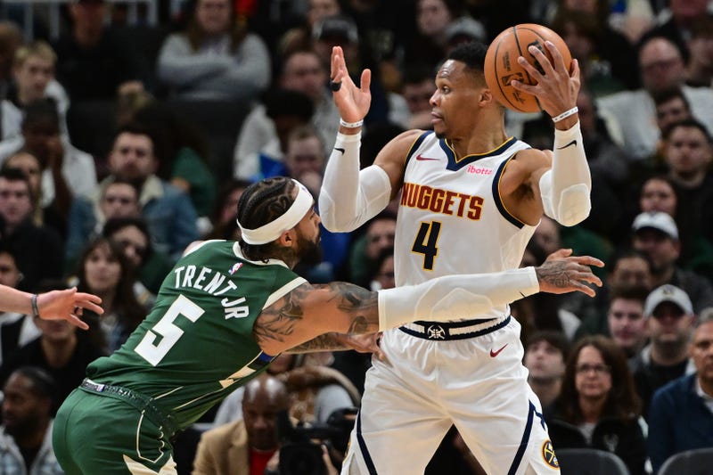 Feb 27, 2025; Milwaukee, Wisconsin, USA; Denver Nuggets guard Russell Westbrook (4) looks to pass the ball away from Milwaukee Bucks guard Gary Trent Jr. (5) in the second quarter at Fiserv Forum. Mandatory Credit: Benny Sieu-Imagn Images