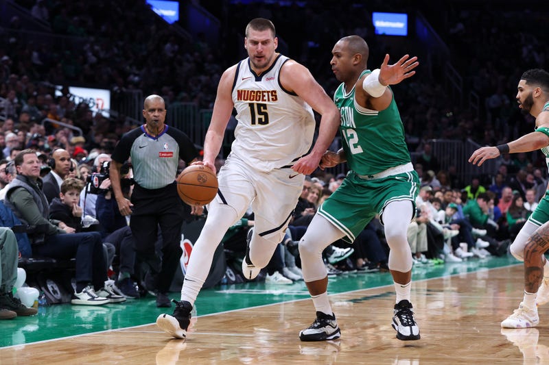 Denver Nuggets center Nikola Jokic (15) dribbles down the court defended by Boston Celtics center Al Horford (42) during the first half at TD Garden.