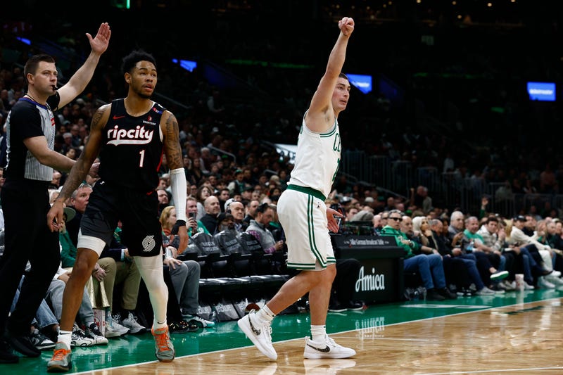 Boston Celtics guard Payton Pritchard (11) follows through on a three point basket as Portland Trail Blazers guard Anfernee Simons (1) looks on during the first quarter at TD Garden.