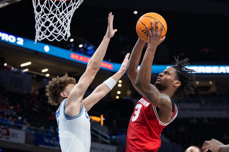 Mar 14, 2025; Indianapolis, IN, USA; Wisconsin Badgers forward Xavier Amos (13) shoots the ball while UCLA Bruins guard Trent Perry (1) defends in the second half at Gainbridge Fieldhouse. Mandatory Credit: Trevor Ruszkowski-Imagn Images