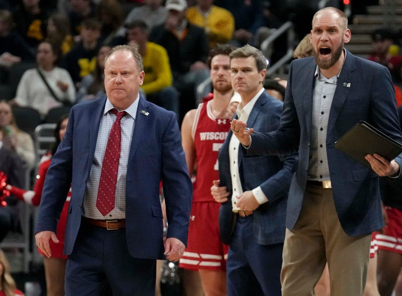 Wisconsin Badgers head coach Greg Gard (left) walks onto the court during a time out in the first half of the 2025 TIAA Big Ten Men’s Basketball Tournament final game against the Michigan Wolverines on Sunday, March 16, 2025, at Gainbridge Fieldhouse in Indianapolis. Michigan defeated Wisconsin 59-53.