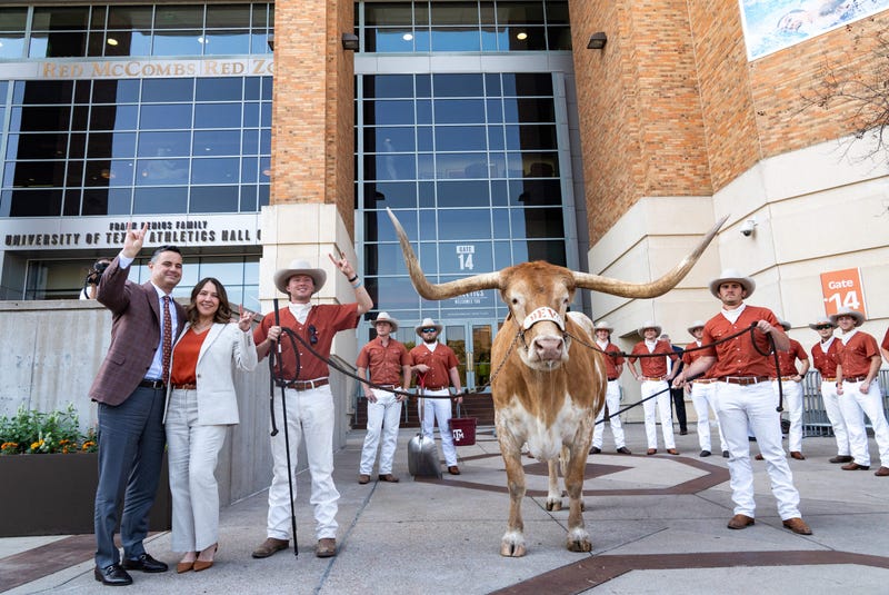 Sean Miller and his wife, Amy Miller, pose with Bevo as The University of Texas announces Miller as their new men's basketball coach Tuesday, March 25, 2025.