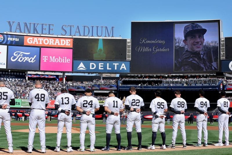 New York Yankees players stand for a moment of silence to honor the memory of Miller Gardner at Yankee Stadium on March 27, 2025