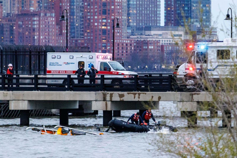 Crew members dive in the water in the Hudson River at the scene of a helicopter crash that killed six people on April 10, 2025.