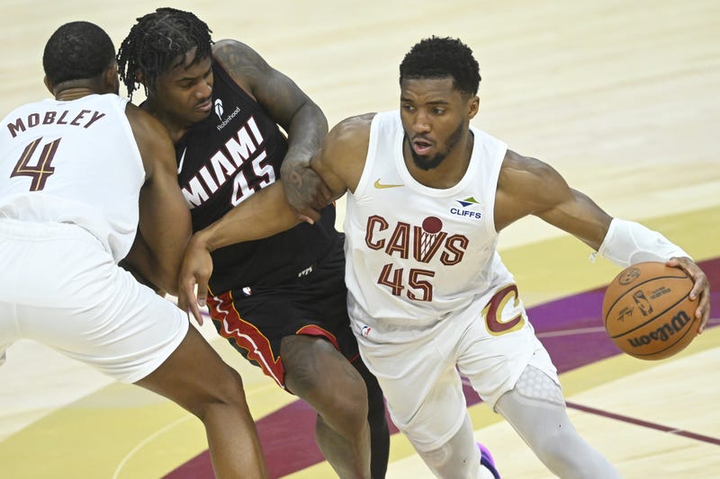 Apr 23, 2025; Cleveland, Ohio, USA; Cleveland Cavaliers forward Evan Mobley (4) sets a pick as guard Donovan Mitchell (45) dribbles around Miami Heat guard Davion Mitchell (45) in the fourth quarter of game two of the first round of the 2025 NBA Playoffs at Rocket Arena. 