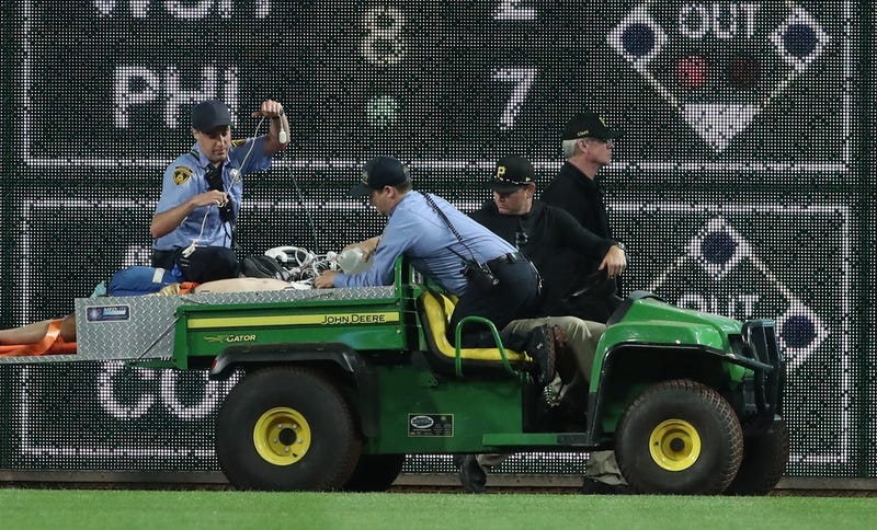 Stadium security and Pittsburgh Pirates medical personnel cart a fan who fell from the stands to the field to an ambulance as the Pirates batted against the Chicago Cubs