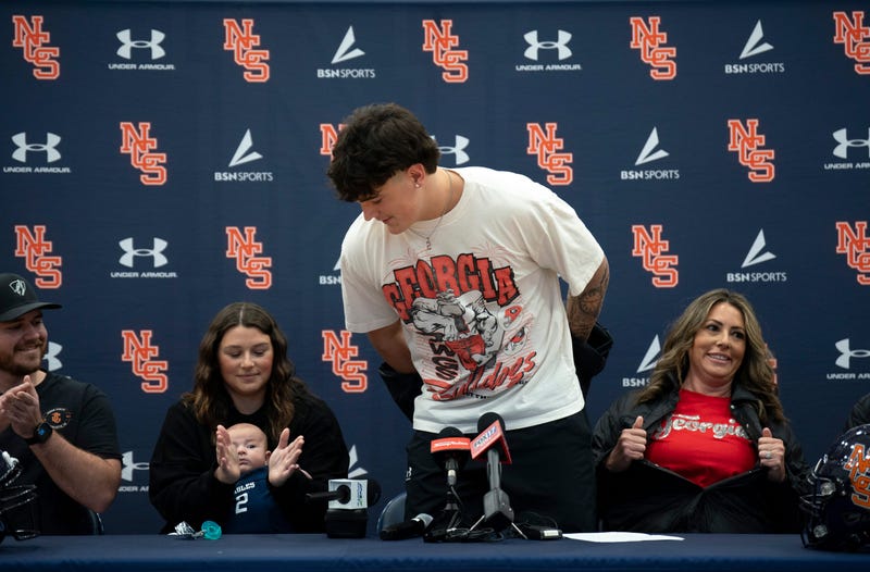 Nashville Christian's five-star quarterback Jared Curtis unveils his new t-shirt and his decision to sign with Georgia with his family at his side