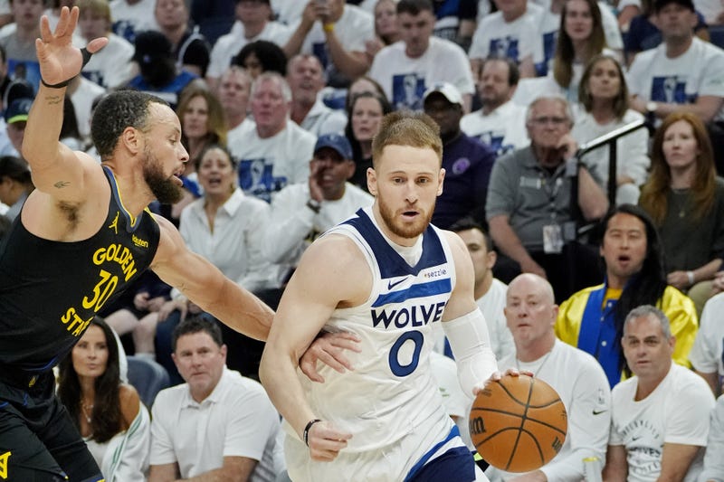 Timberwolves guard Donte DiVincenzo (0) dribbles around Golden State Warriors guard Stephen Curry (30) in the first quarter of game one. Curry later left the game with a hamstring injury that could keep him out at least a week.