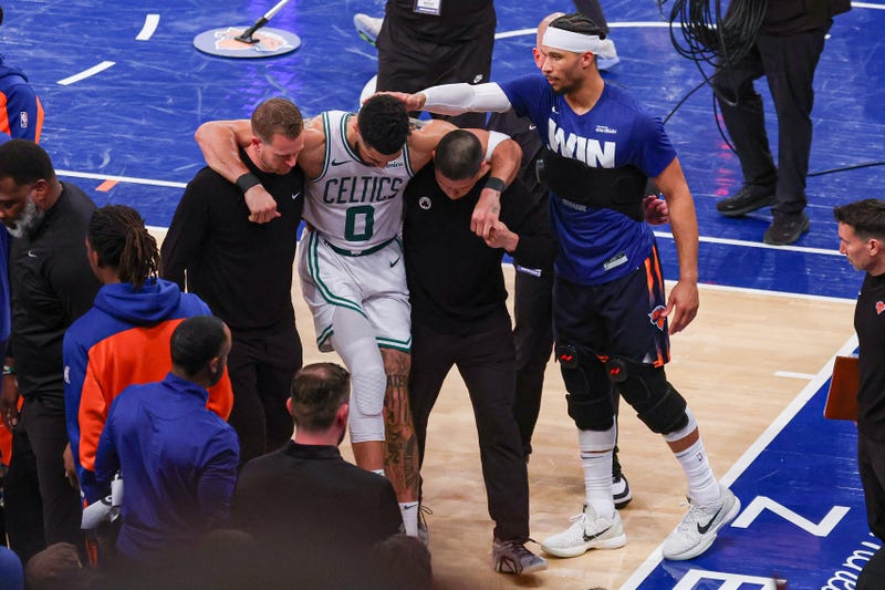 New York, New York, USA; Boston Celtics forward Jayson Tatum (0) is helped off the court by after an injury in the second half during game four of the second round for the 2025 NBA Playoffs as New York Knicks guard Josh Hart (3) gestures at Madison Square Garden. Tatum would leave the game with an injury after this play.