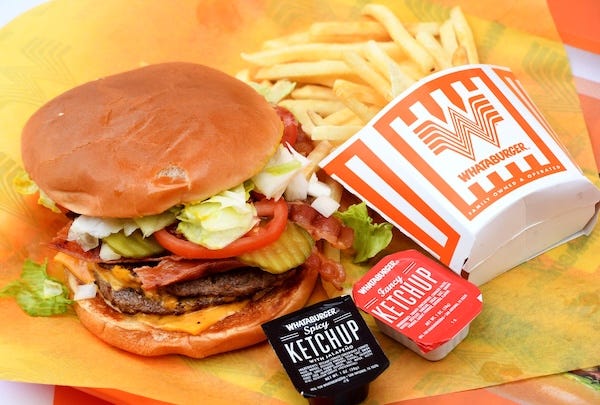 A double meat Whataburger with cheese and bacon, with a side of fries