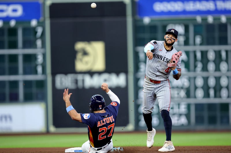 Minnesota Twins shortstop Carlos Correa (4) throws a fielded ball to first base to complete a double play against the Houston Astros during the seventh inning at Daikin Park.