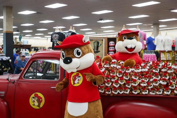 Buc-ee the Beaver dances in front of a display of stuffed toys