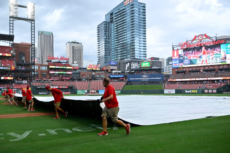 St. Louis Cardinals grounds crew pulls the tarp on the field during a rain delay in the third inning of a game between the St. Louis Cardinals and the Atlanta Braves at Busch Stadium.