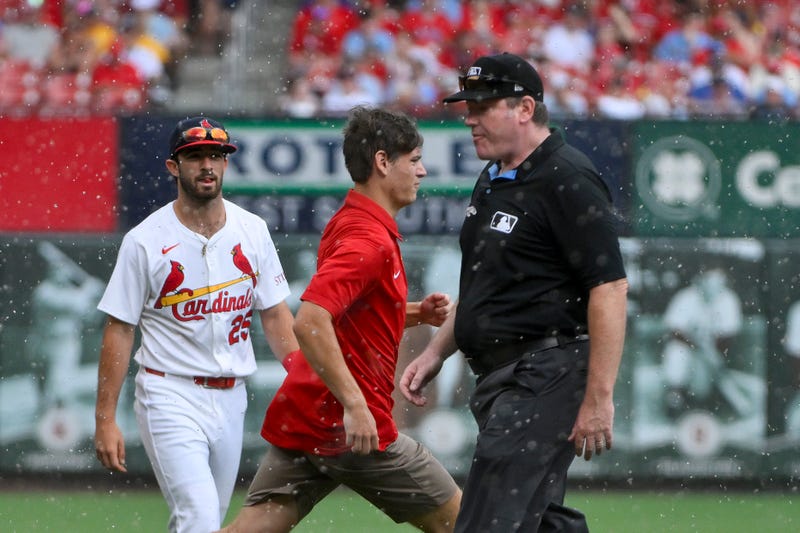 St. Louis Cardinals third baseman Thomas Saggese (25) walks off the field as ground crew runs on the field during a rain delay in the fifth inning against the Atlanta Braves at Busch Stadium.