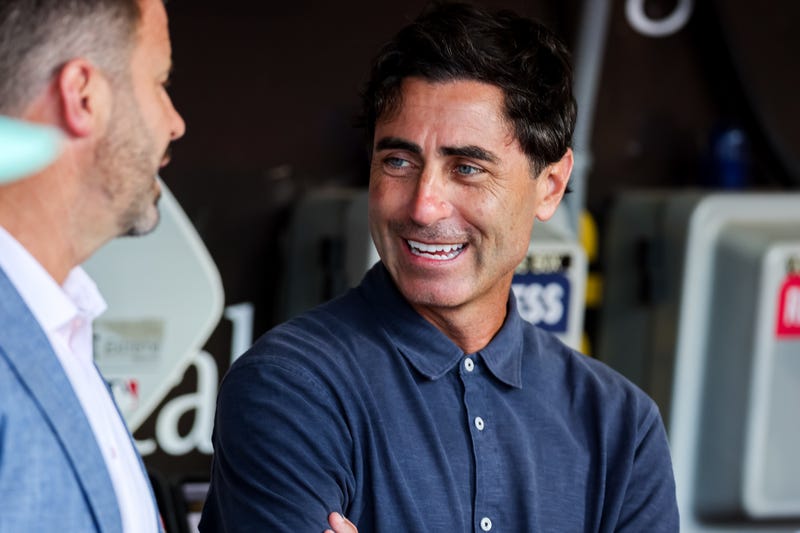 San Diego Padres general manager AJ Preller, right, talks with CEO Erik Greupner in the dugout before the game against the St. Louis Cardinals at Petco Park