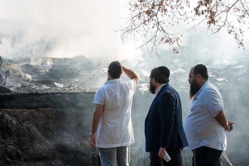 Members of the congregation looks on at the remains of Congregation Beth El synagogue after an overnight fire destroyed the building in Rutherford on Friday, Aug. 8, 2025