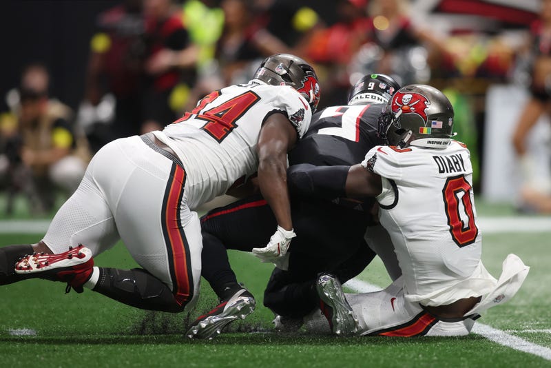 Tampa Bay Buccaneers linebacker Yaya Diaby (0) and defensive tackle Calijah Kancey (94) tackle Atlanta Falcons quarterback Michael Penix Jr. (9) during the second quarter at Mercedes-Benz Stadium.