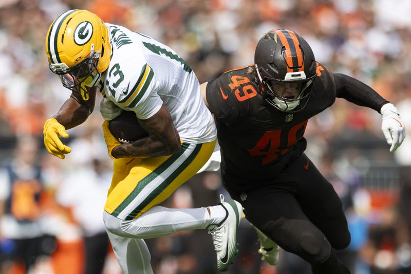 Sep 21, 2025; Cleveland, Ohio, USA; Green Bay Packers wide receiver Dontayvion Wicks (13) breaks a tackle by Cleveland Browns linebacker Carson Schwesinger (49) during the third quarter at Huntington Bank Field. 