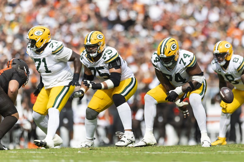 Sep 21, 2025; Cleveland, Ohio, USA; Green Bay Packers guard Elgton Jenkins (74) snaps the ball as guard Sean Rhyan (75) and offensive tackle Anthony Belton (71) move for blocks against the Cleveland Browns during the third quarter at Huntington Bank Field. Mandatory Credit: Scott Galvin-Imagn Images