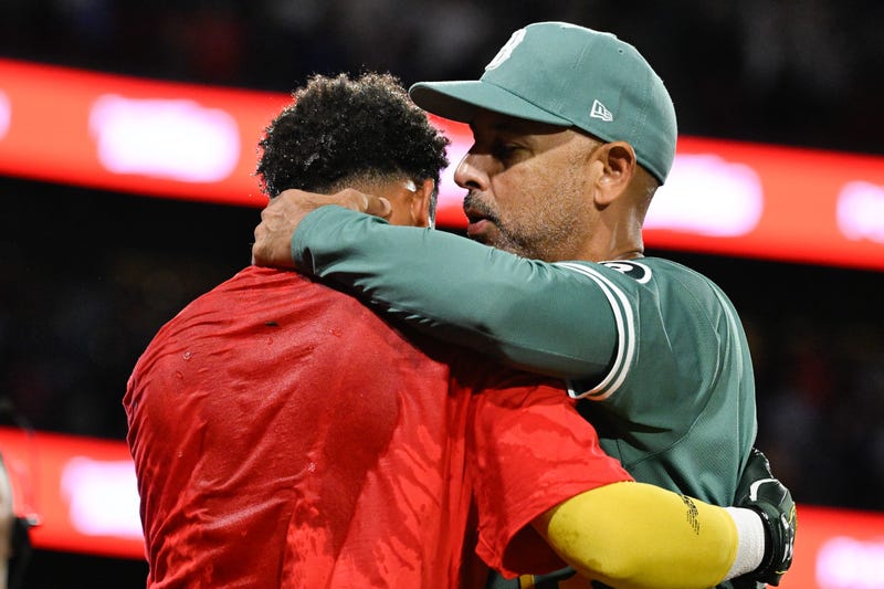 Boston Red Sox manager Alex Cora (right) hugs center fielder Ceddanne Rafaela (3) as they celebrate clinching a playoff spot after defeating the Detroit Tigers in the ninth inning at Fenway Park.