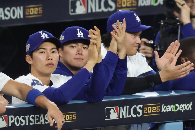 Los Angeles Dodgers second baseman Hyeseong Kim (6), pitcher Yoshinobu Yamamoto (18), and two-way player Shohei Ohtani (17) watch the game from the dugout in the ninth inning against the Milwaukee Brewers in game four of the NLCS round for the 2025 MLB playoffs at Dodger Stadium.