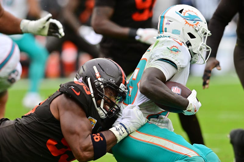 Oct 19, 2025; Cleveland, Ohio, USA; Cleveland Browns defensive end Myles Garrett (95) tackles Miami Dolphins running back De'Von Achane (28) during the second half at Huntington Bank Field. Mandatory Credit: Ken Blaze-Imagn Images