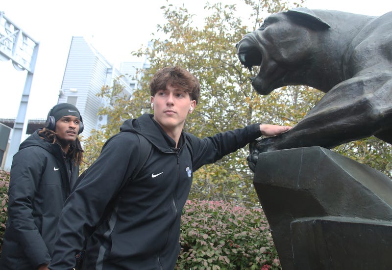 Mason Heintschel touching the Panthers statue