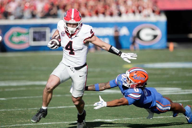 Georgia Bulldogs tight end Oscar Delp (4) evades Florida Gators defensive back Sharif Denson (0) in the first quarter at EverBank Stadium.