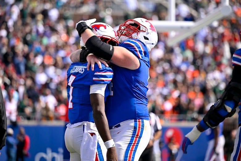 SMU Mustangs quarterback Kevin Jennings (7) and offensive lineman Joshua Bates (64) celebrates after Jennings scores a touchdown against the Miami Hurricanes during the second half at Gerald J. Ford Stadium