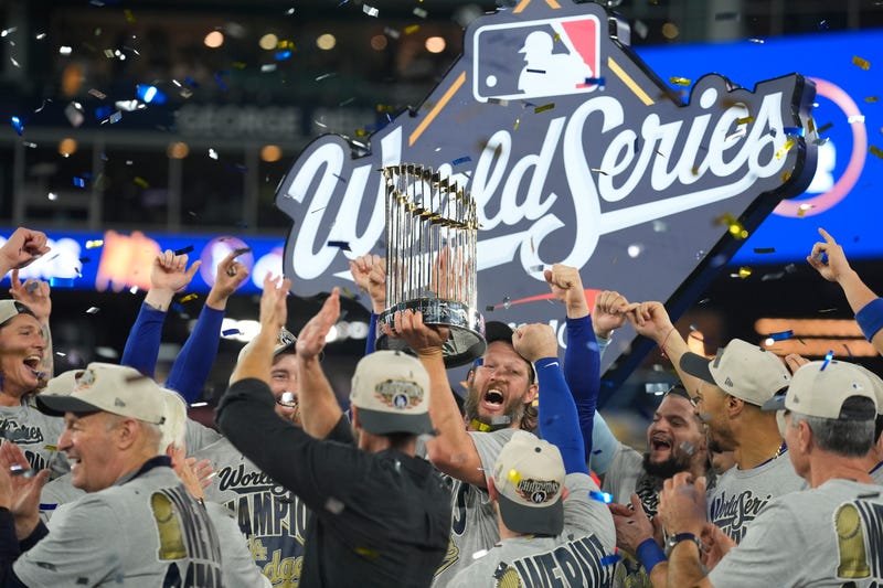 Los Angeles Dodgers pitcher Clayton Kershaw (22) celebrates with the Commissioner's Trophy on the podium after defeating the Toronto Blue Jays in the 2025 MLB World Series at Rogers Centre.
