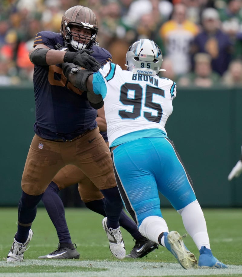 Green Bay Packers guard Aaron Banks (65) blocks Carolina Panthers defensive end Derrick Brown (95) during the first quarter of their game Sunday, November 2, 2025 at Lambeau Field in Green Bay, Wisconsin.