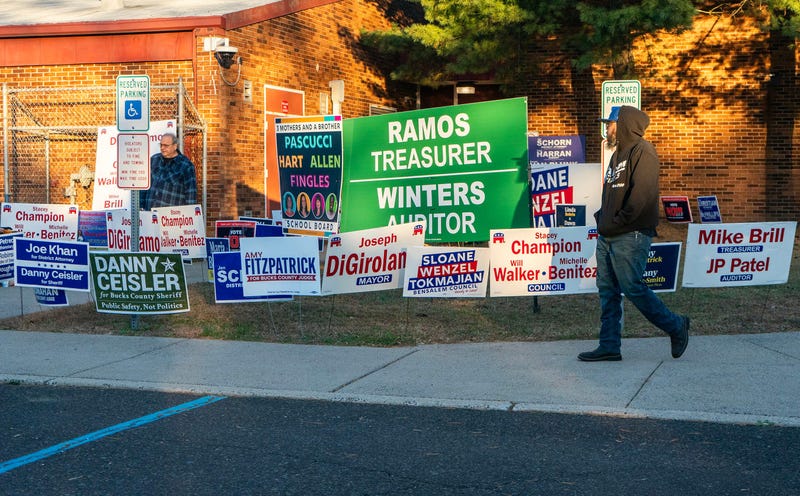 Voters walk past the election lawn signs at the Belmont Hills Elementary School polling location in Bensalem on Nov. 4, 2025.