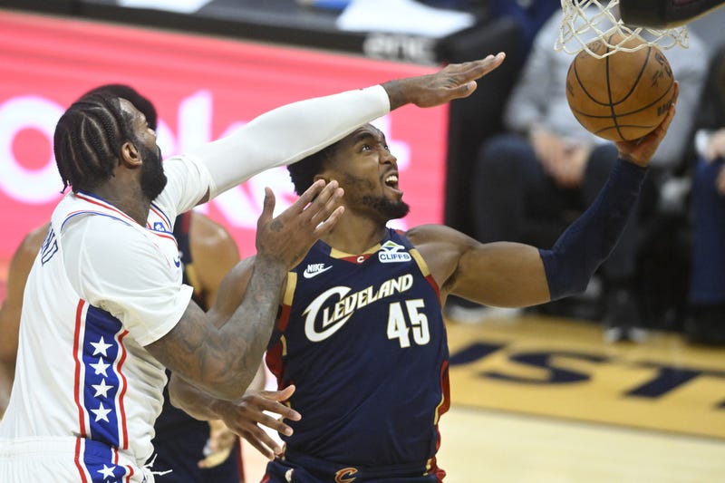 Nov 5, 2025; Cleveland, Ohio, USA; Cleveland Cavaliers guard Donovan Mitchell (45) drives to the basket beside Philadelphia 76ers center Andre Drummond (1) in the fourth quarter at Rocket Arena.