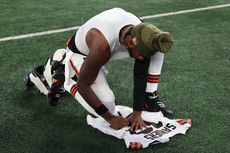 Nov 9, 2025; East Rutherford, New Jersey, USA; Cleveland Browns quarterback Shedeur Sanders (12) signs his jersey on the field after the game against the New York Jets at MetLife Stadium. Mandatory Credit: Vincent Carchietta-Imagn Images