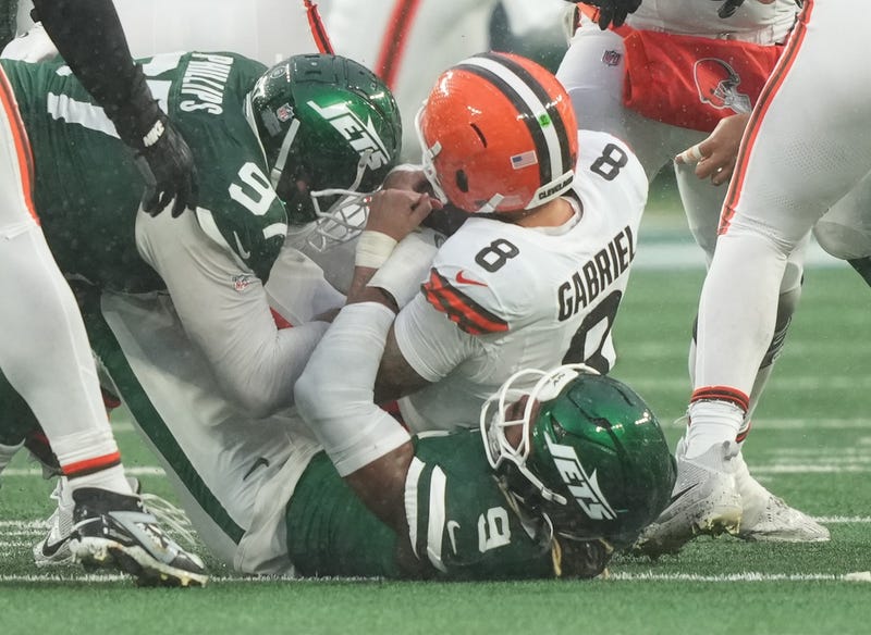 Nov 9, 2025; East Rutherford, New Jersey, USA; Cleveland Browns quarterback Dillon Gabriel (8) is taken down by New York Jets defensive end Will McDonald IV (9) and defensive tackle Harrison Phillips (97) in the second half at MetLife Stadium. 