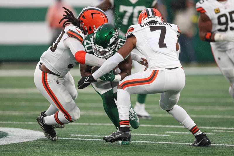 Nov 9, 2025; East Rutherford, New Jersey, USA; New York Jets running back Breece Hall (20) is tackled by Cleveland Browns cornerback Tyson Campbell (7) and linebacker Devin Bush (30) during the second half at MetLife Stadium. Mandatory Credit: Vincent Carchietta-Imagn Images