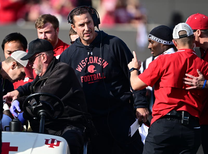 Nov 15, 2025; Bloomington, Indiana, USA; Wisconsin Badgers head coach Luke Fickell stands in the crowd surrounding an injured Wisconsin Badgers running back Gideon Ituka during the second half against the against the Indiana Hoosiers at Memorial Stadium. Mandatory Credit: Marc Lebryk-Imagn Images