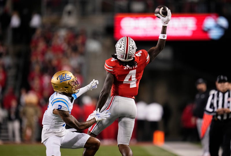 Ohio State Buckeyes wide receiver Jeremiah Smith (4) makes a one-handed catch in front of UCLA Bruins defensive back Andre Jordan Jr. (2) during the NCAA football game at Ohio Stadium in Columbus on Nov. 15, 2025.