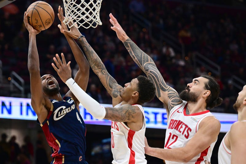 Nov 19, 2025; Cleveland, Ohio, USA; Cleveland Cavaliers center Evan Mobley (4) goes to the basket against Houston Rockets forward Jabari Smith Jr. (10) and center Steven Adams (12) during the second half at Rocket Arena. 
