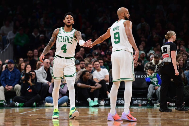 Boston Celtics guard Anfernee Simons (4) is congratulated by guard Derrick White (9) after a basket during the first half at TD Garden.