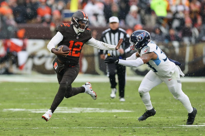 Cleveland Browns quarterback Shedeur Sanders (12) runs with the ball against Tennessee Titans linebacker Cedric Gray (33) during the second quarter at Huntington Bank Field.