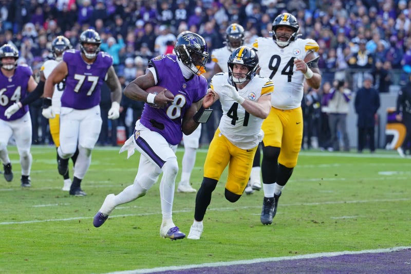 Dec 7, 2025; Baltimore, Maryland, USA; Baltimore Ravens quarterback Lamar Jackson (8) runs with the ball for a touchdown against Pittsburgh Steelers linebacker Payton Wilson (41) during the first half at M&T Bank Stadium.