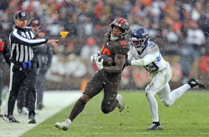 Cleveland Browns running back Quinshon Judkins (10) runs to the sideline ahead of Tennessee Titans cornerback Darrell Baker Jr. (39) as a flag for holding flies during the second half of an NFL football game at Huntington Bank Field, Dec. 7, 2025, in Cleveland, Ohio.