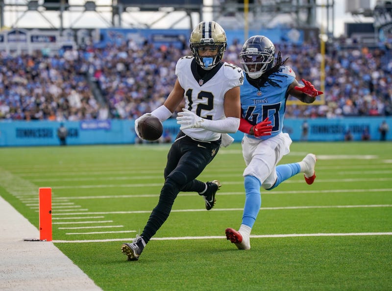 Dec 28, 2025; Nashville, Tennessee, USA; New Orleans Saints wide receiver Chris Olave (12) runs in a touchdown in front of Tennessee Titans cornerback Kemon Hall (40) during the third quarter at Nissan Stadium. Mandatory Credit: Andrew Nelles-USA TODAY Network via Imagn Images