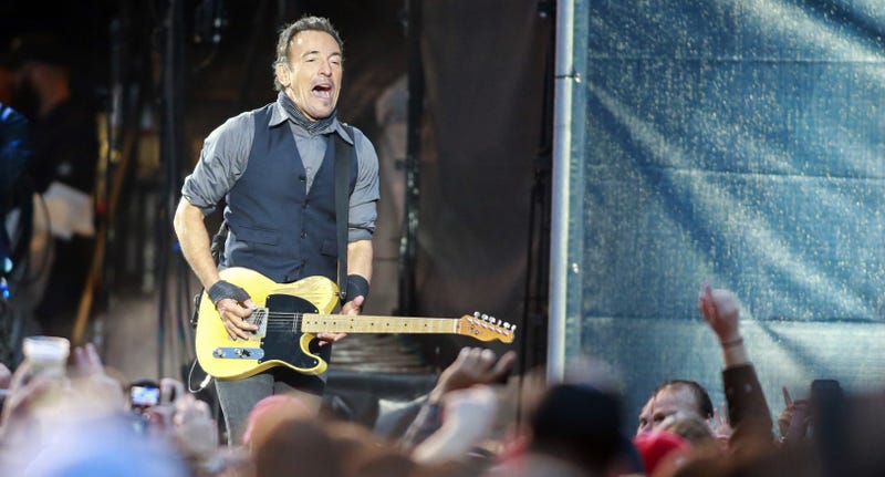 Bruce Springsteen sing and playing his guitar onstage
